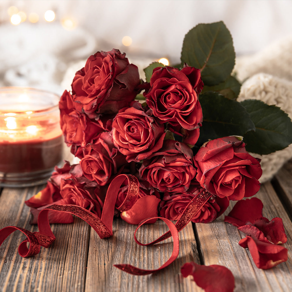 Anniversary bouquet of red roses with candle.