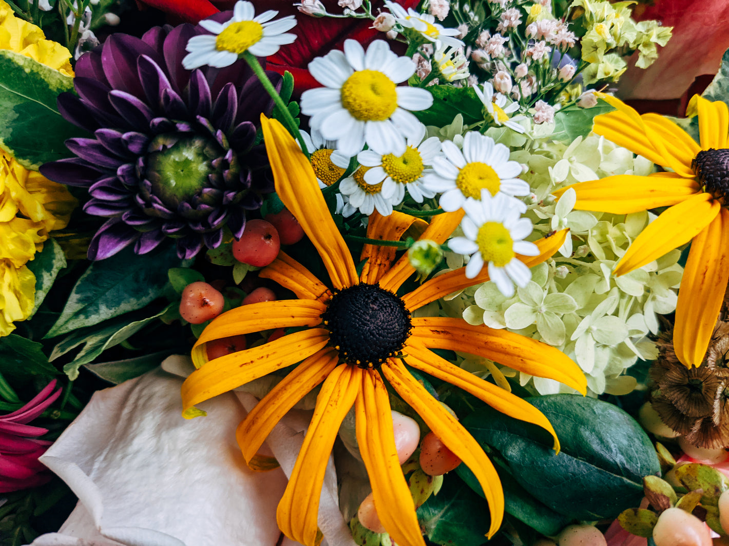 Close-up of vibrant yellow flower bouquet with daisies and other colorful...