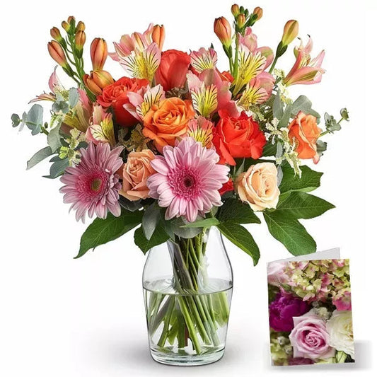 A colorful bouquet of pink gerberas, orange roses, and alstroemeria in a clear glass vase.
