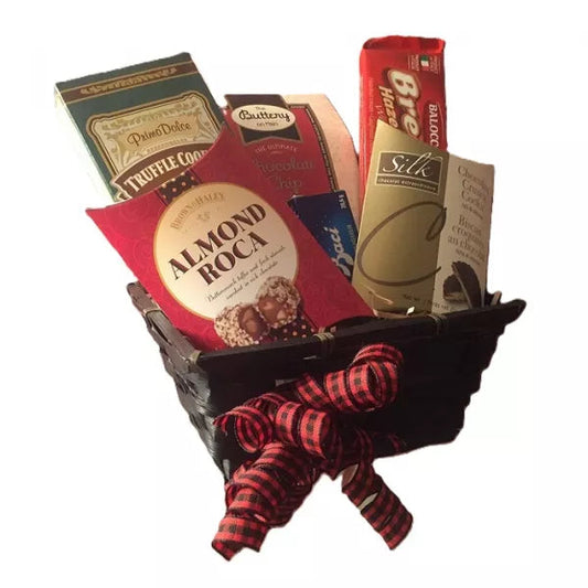 A gift basket filled with assorted chocolate boxes and a red bow.