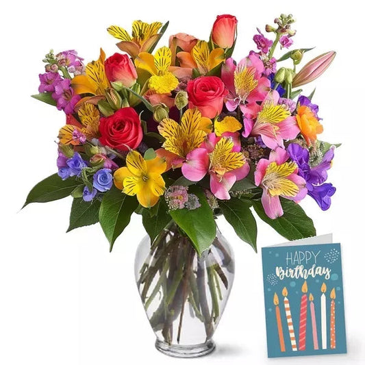 A colorful bouquet of mixed flowers in a vase with a 'Happy Birthday' card.