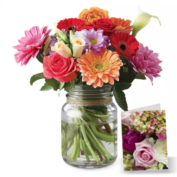 A colorful bouquet of mixed flowers in a mason jar, with stems visible through the glass.