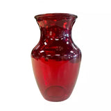 A red glass vase on a white background.