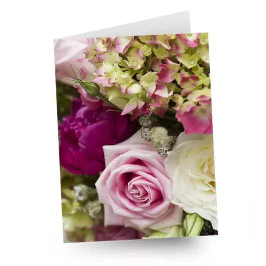 A close-up of a bouquet featuring pink roses and assorted flowers.